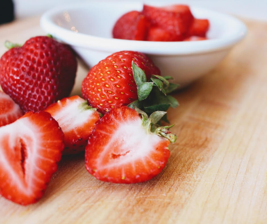 cut and whole strawberries in a bowl