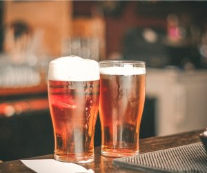 2 glasses of beer on a bar. There is a link between beer and breast cancer